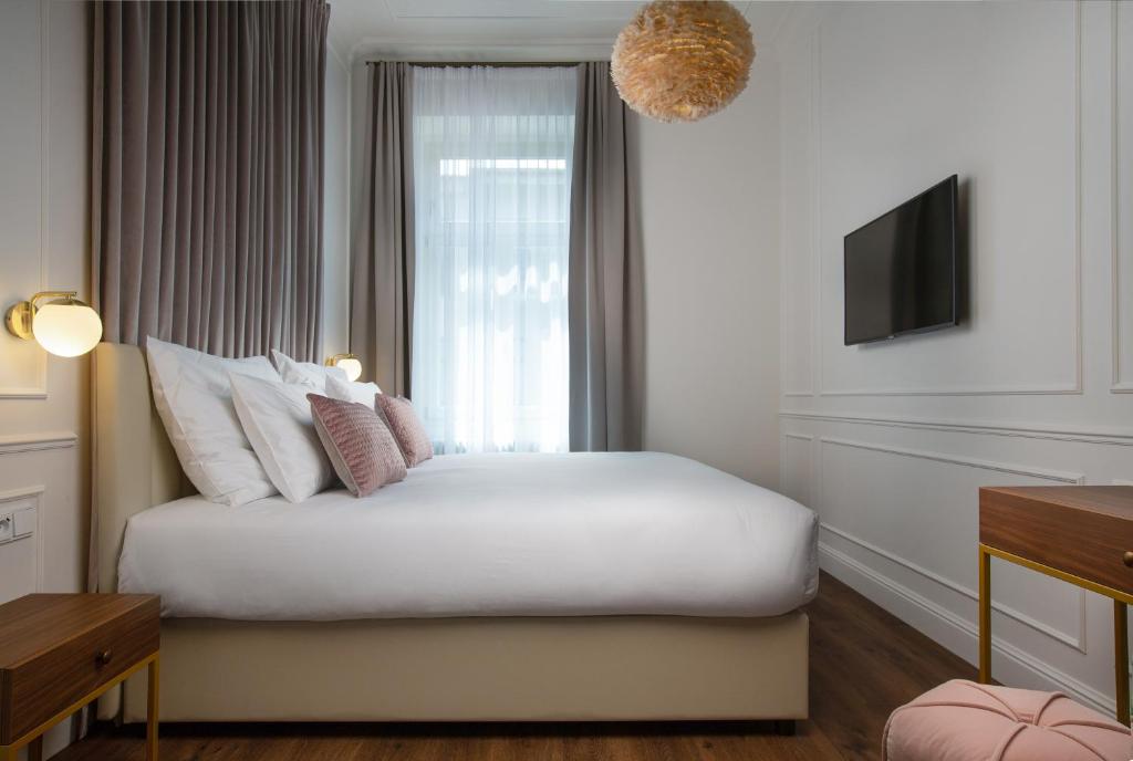 een slaapkamer met een wit bed en een raam bij OREA Place Seno in Praag