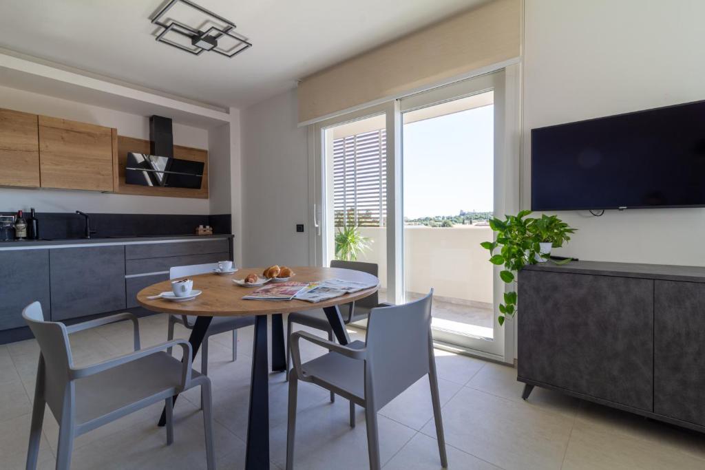 uma cozinha e sala de jantar com mesa e cadeiras em Istai Poetto Apartment em Cagliari