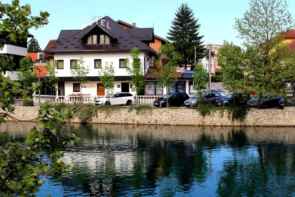 una casa con coches aparcados frente a un río en Holiday In Bihać, en Bihać