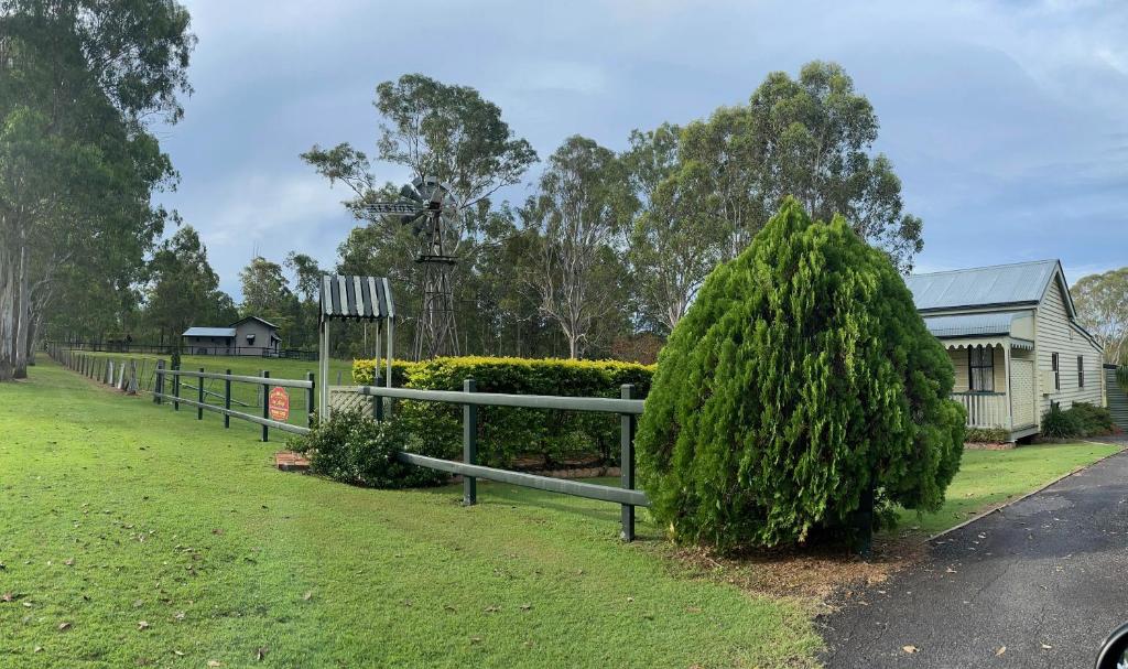 una cerca y un arbusto delante de una casa en Belvoir B&B Cottages, en Grafton