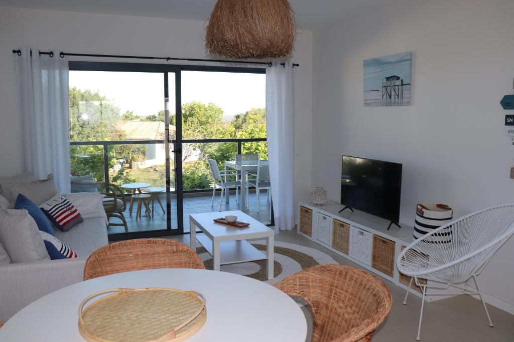 a living room with a table and chairs and a television at ROOF TOP SEA VIEW ALVOR in Alvor