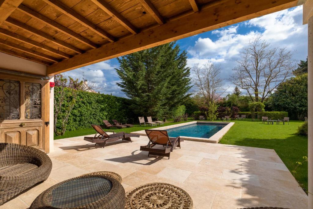 een patio met stoelen en een zwembad bij Hôtel Le Clos in Montagny-lès-Beaune