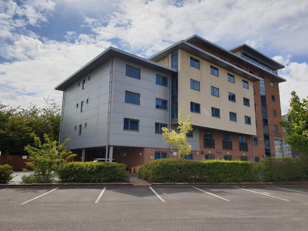 un grand bâtiment blanc avec un parking dans l'établissement Legacy Preston International Hotel, à Preston