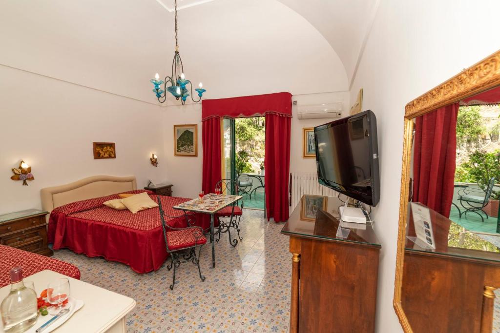 ein Wohnzimmer mit einem Bett und einem TV in der Unterkunft Casa Teresa in Positano