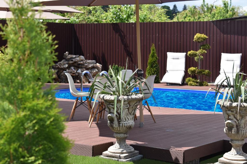 une terrasse avec une table, des chaises et un parasol dans l'établissement Pensiunea Casa Zece, à Turda