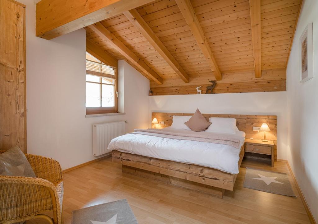 ein Schlafzimmer mit einem Bett in einem Zimmer mit Holzdecken in der Unterkunft Appartements Klausner in Altenmarkt im Pongau