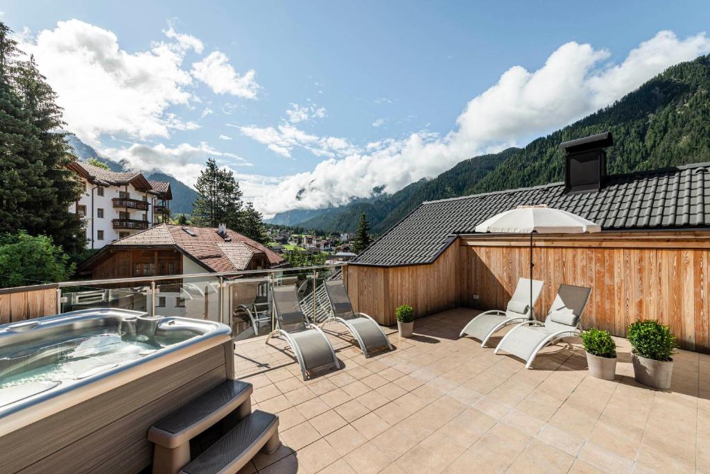 een patio met stoelen en een hot tub op een balkon bij Apartment Cinch Residence Bun Ste in San Vigilio Di Marebbe