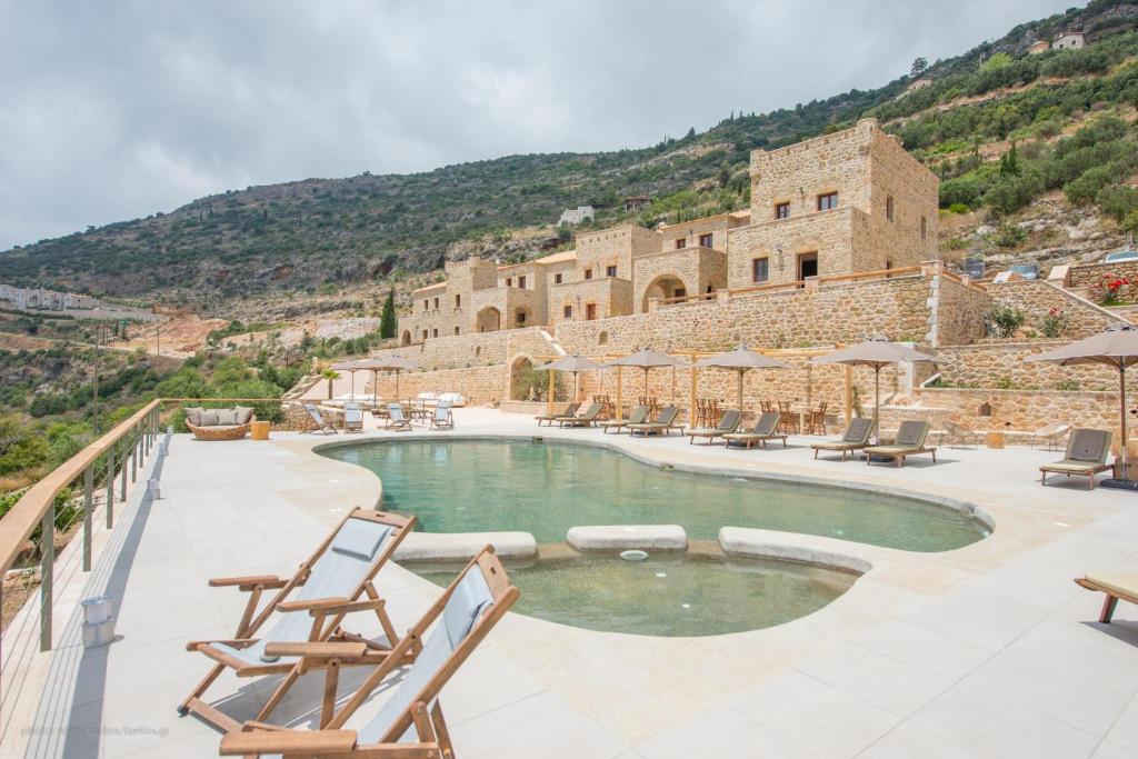 a swimming pool with chairs and a building at Brazzo di Maina in Oítilon