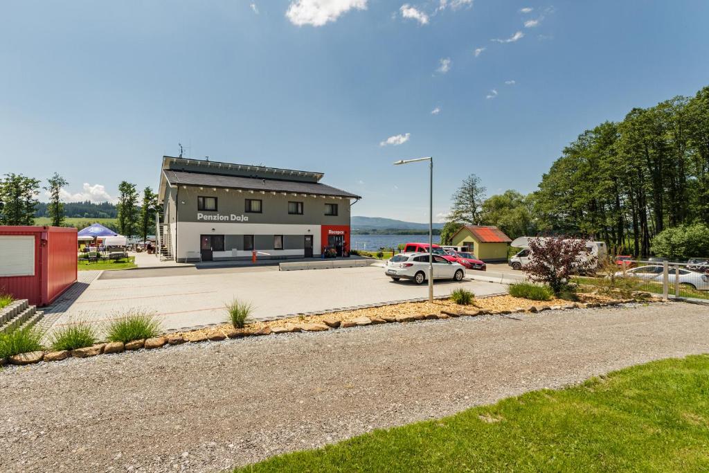 een gebouw met een auto geparkeerd op een parkeerplaats bij Penzion DaJa in Horní Planá