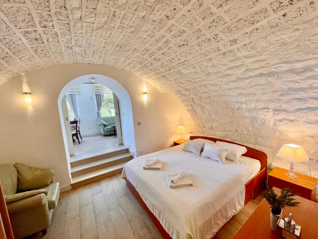 una camera da letto con un grande letto e un soffitto in pietra di Ida 2 Apartments a Dubrovnik