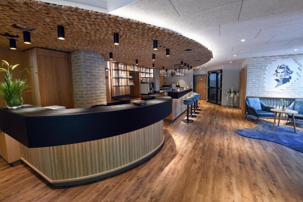 a lobby with a bar and chairs in a building at Hotel Beethoven in Hinterbrühl