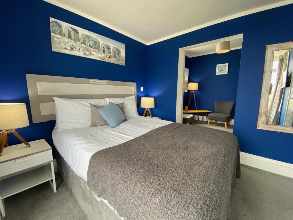 una camera da letto con pareti blu e un grande letto di The Lyncroft a Newquay