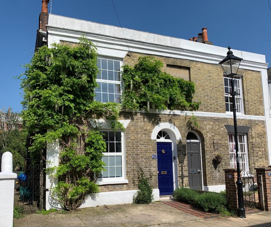 une maison en briques avec une porte bleue dans l'établissement Esme's, à Winchester