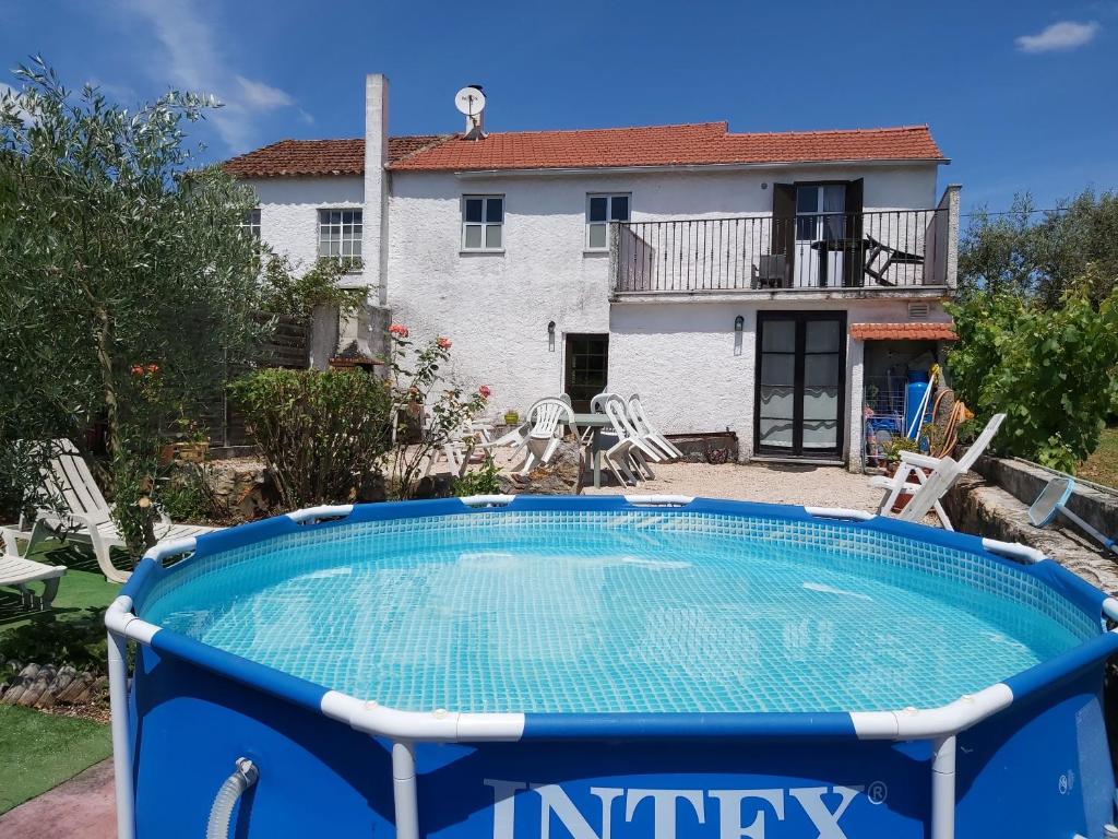 a pool with a house in the background at Casa de Alagoa in Arganil