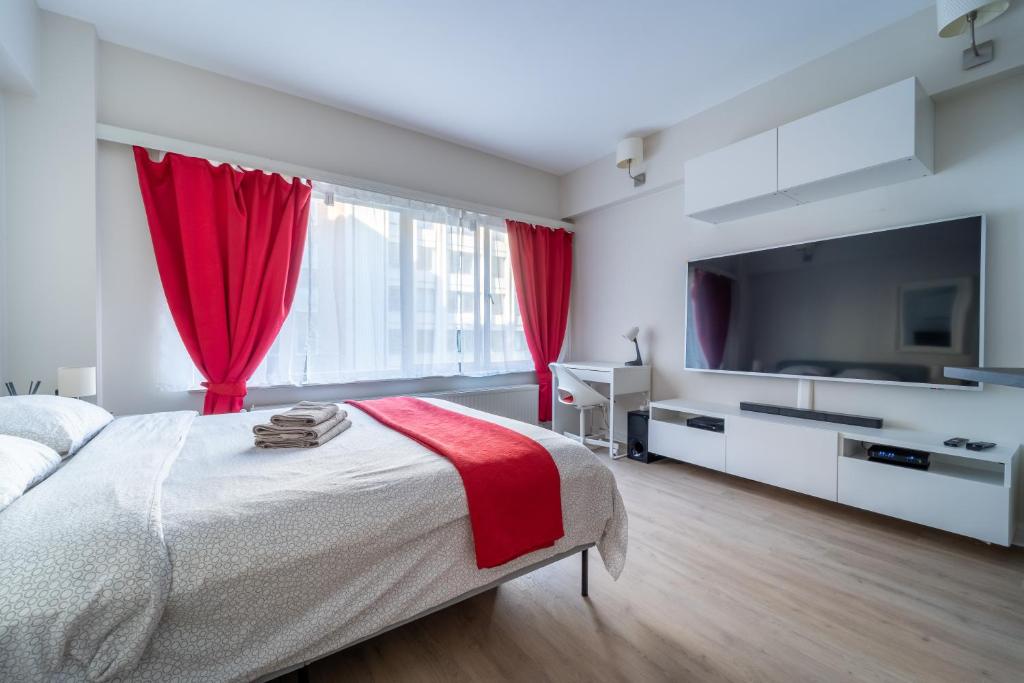 una camera da letto con un grande letto con tende rosse di Luxury Studio In the EU Area a Bruxelles