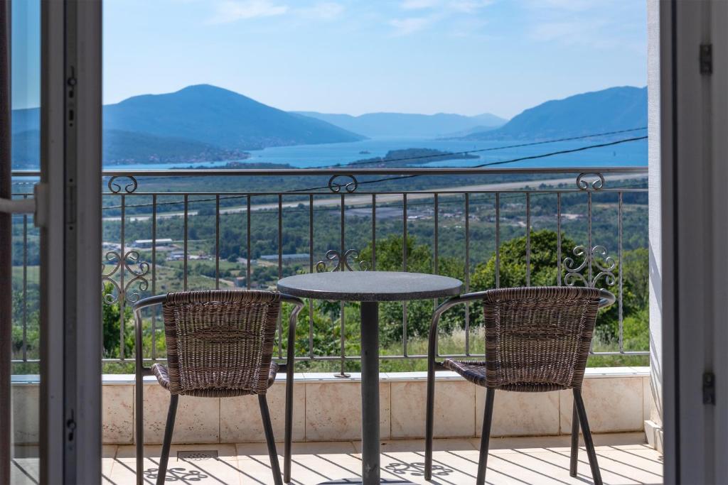 a table and two chairs on a balcony with a view at Guest house Vila Vedesa in Kotor