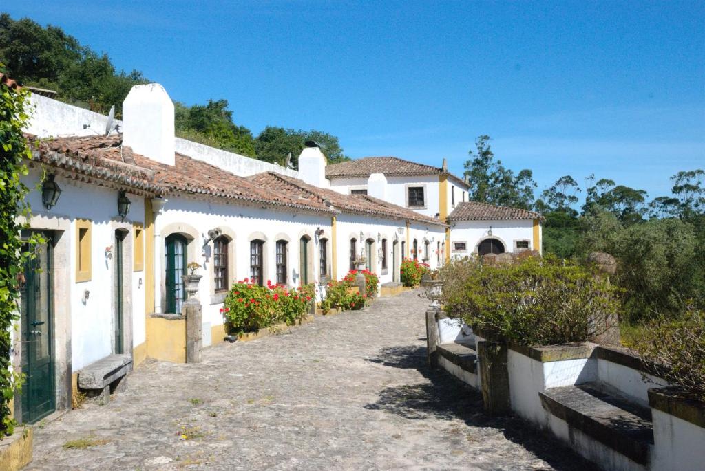 een rij witte en gele huizen in een straat bij Quinta do Brejo - Turismo Equestre in Malveira