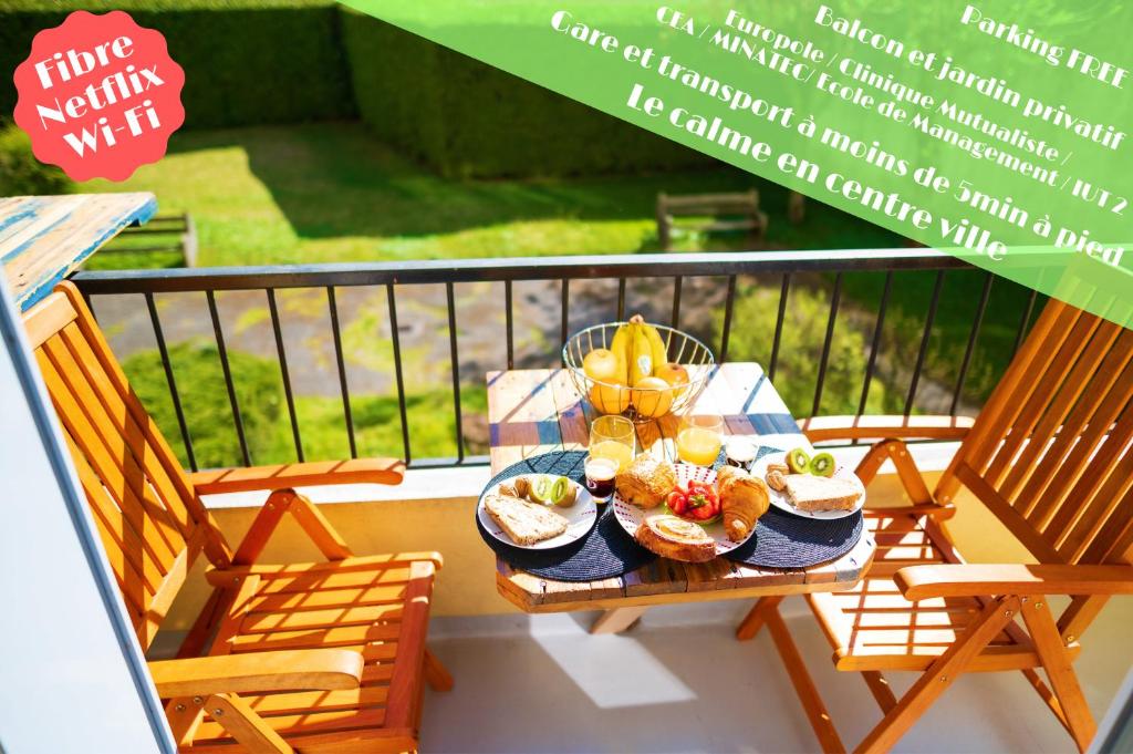 een tafel met eten op een balkon met stoelen bij Gare - Polygone Scientifique - Palais de Justice in Grenoble