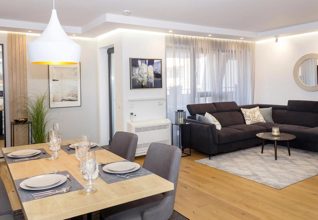 a living room with a table and a couch at Sea&City Deluxe Apartment - Top Center Varna in Varna City