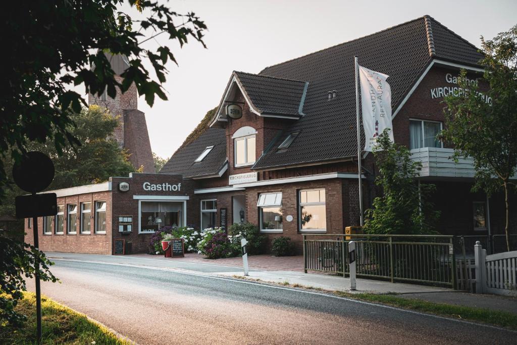 un edificio con un cartello sul lato di una strada di Kirchspielkrug Landhotel & Restaurant a Westerhever