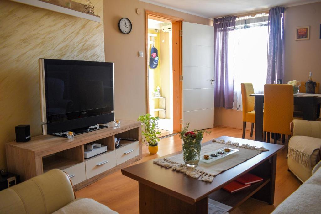 a living room with a television and a table at Golden BIS, Subotica in Subotica