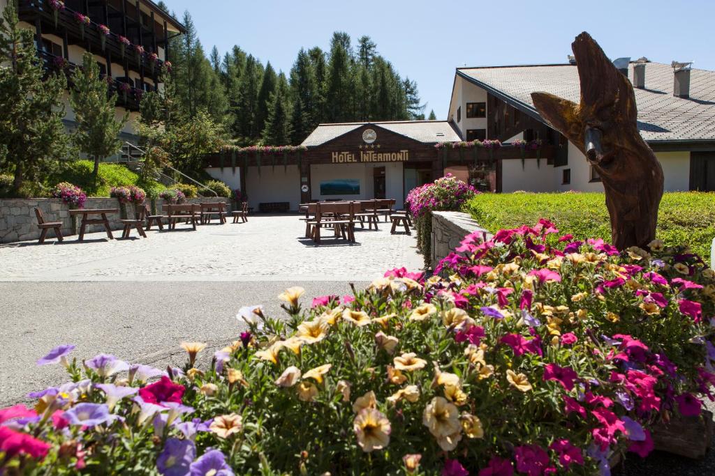 um jardim com flores em frente a um edifício em Hotel Intermonti em Livigno