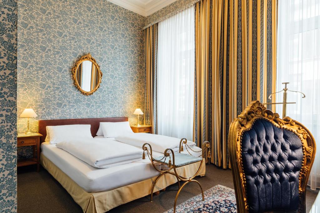 - une chambre avec un lit, un miroir et une chaise dans l'établissement Das Kleine Hotel in ruhiger Stadtlage, à Wiesbaden