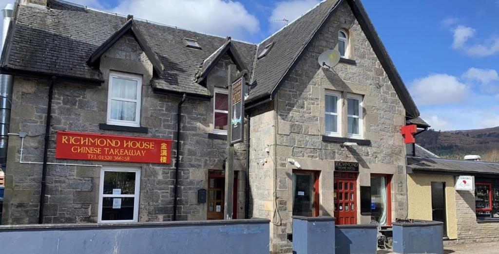 een oud stenen gebouw met een bord voor een restaurant bij Richmond House Hotel in Fort Augustus