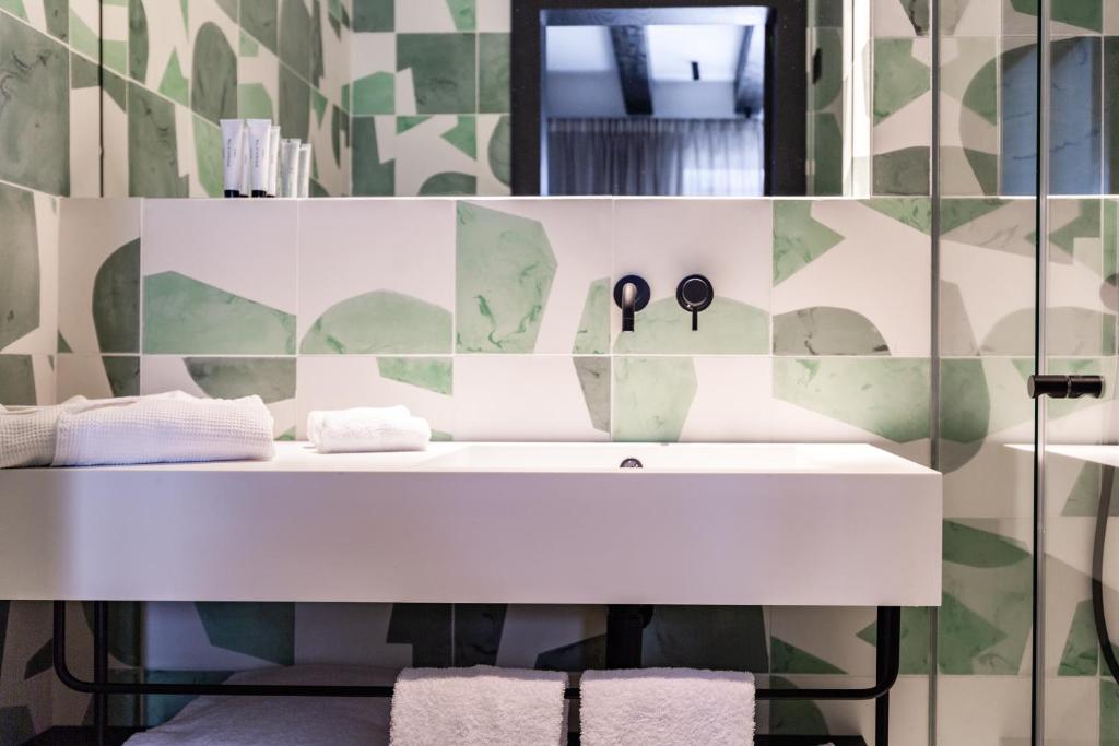 ein Badezimmer mit einem weißen Waschbecken und einem Spiegel in der Unterkunft Concepcio by Nobis, Palma, a Member of Design Hotels in Palma de Mallorca