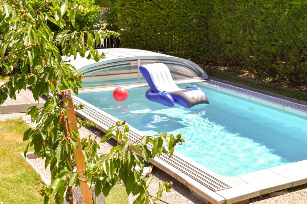 una piscina con una silla y una pelota en Pension Föhrenhain, en Gerasdorf bei Wien