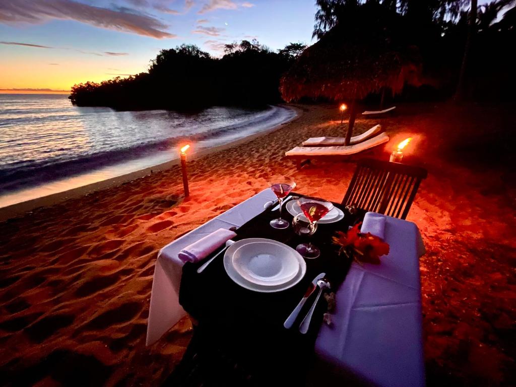 - une table sur la plage avec une assiette de nourriture dans l'établissement Hotel Océan Beach Sakatia, à Nosy Be