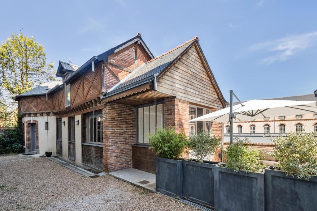 a brick house with a fence in front of it at Maison Sévigné - Le calme du Thabor et la proximité du centre ville in Rennes