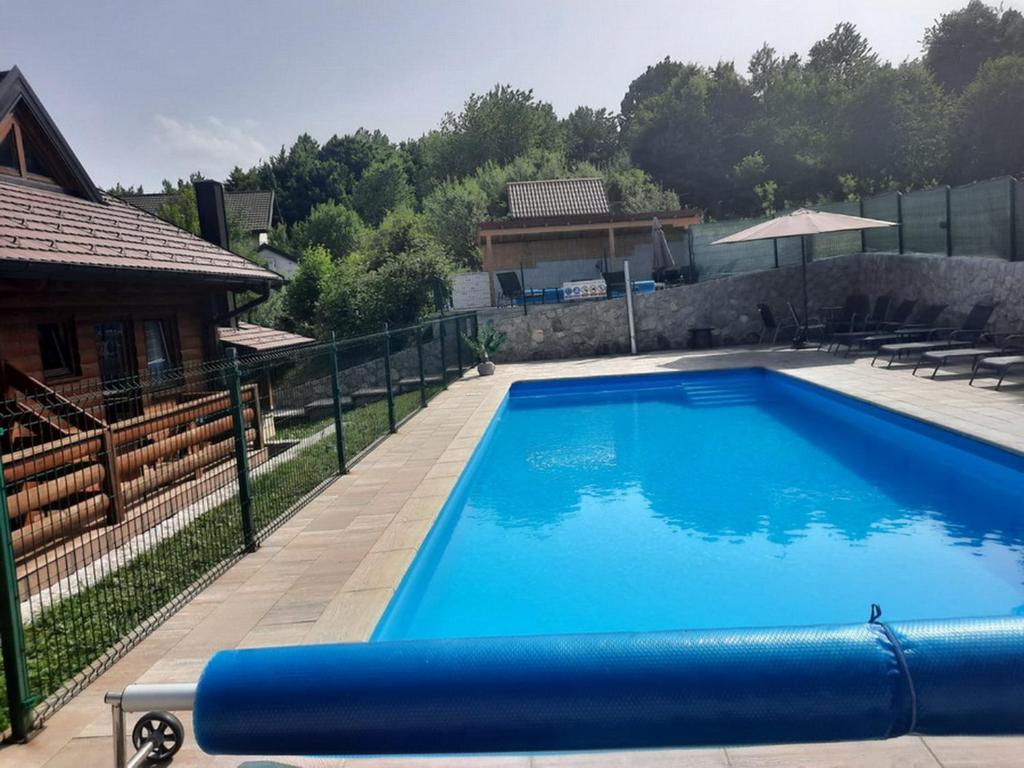 ein großer blauer Pool neben einem Haus in der Unterkunft Guesthouse Sara in Grabovac