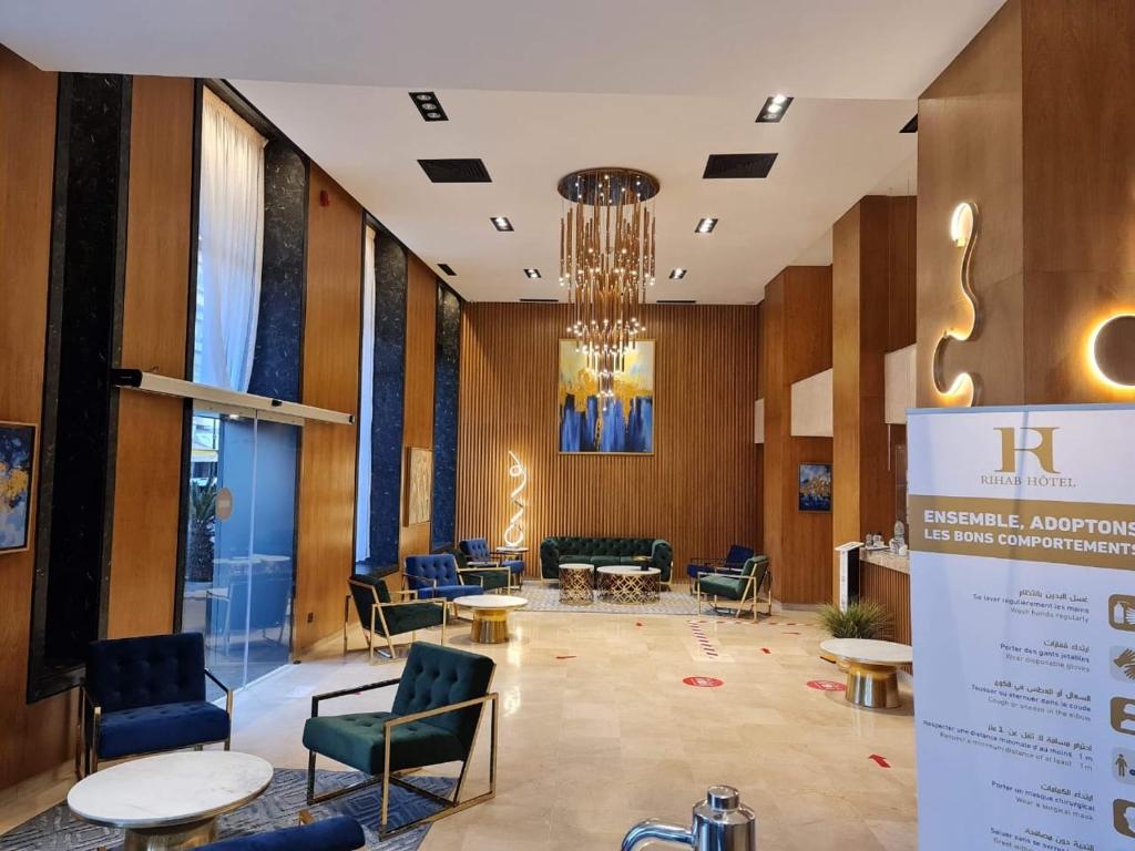 een lobby met stoelen en tafels en een kroonluchter bij Rihab Hotel in Rabat