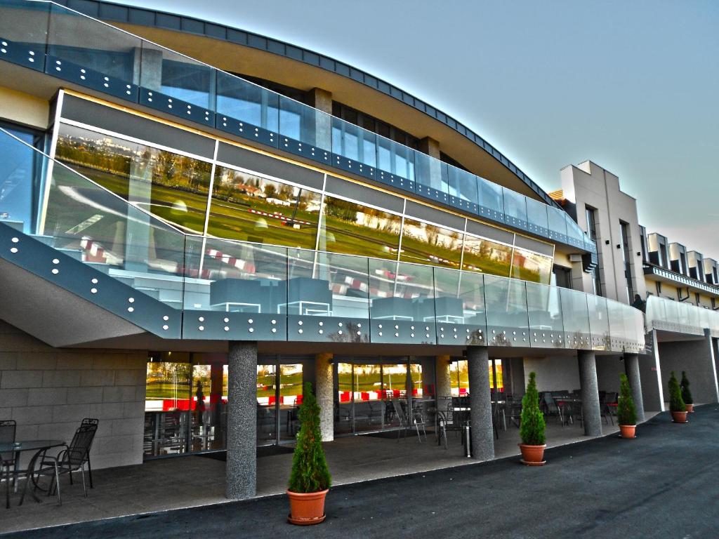 un grand bâtiment avec quelques plantes devant lui dans l'établissement Gokart Hotel, à Kecskemét