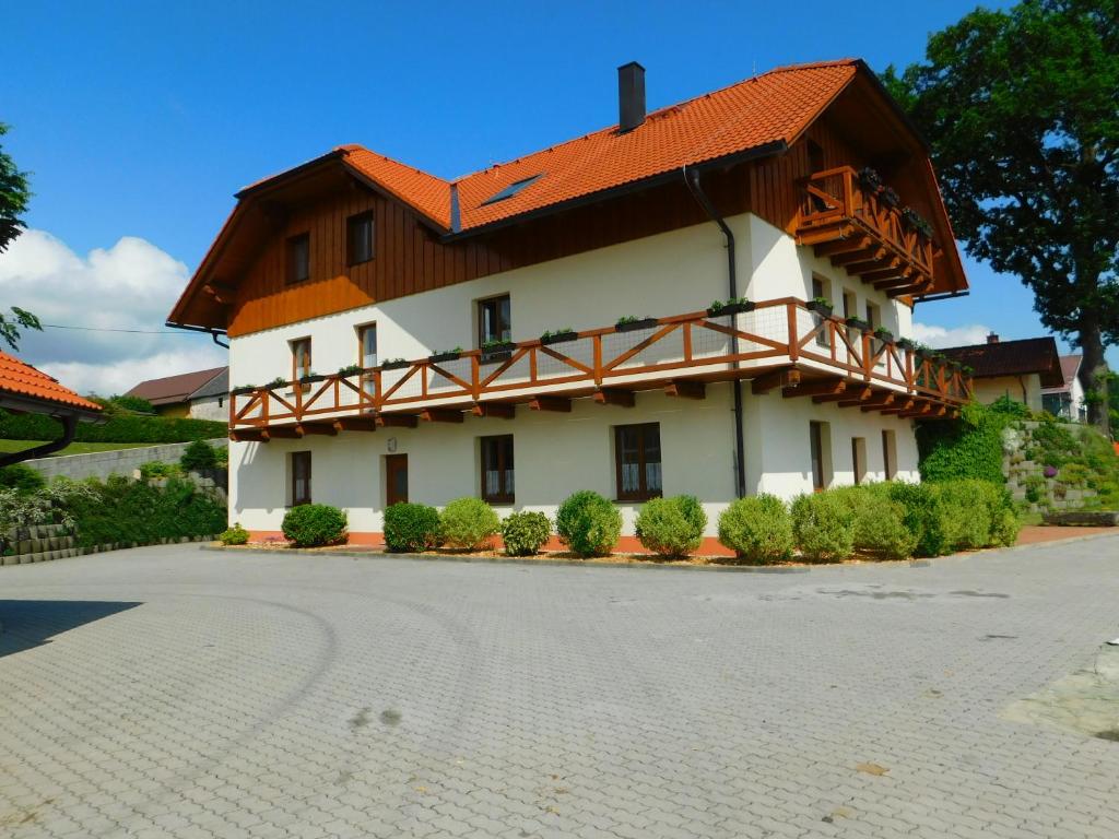 een wit gebouw met een oranje dak bij Apartmány U Srdce Vltavy in Horní Planá