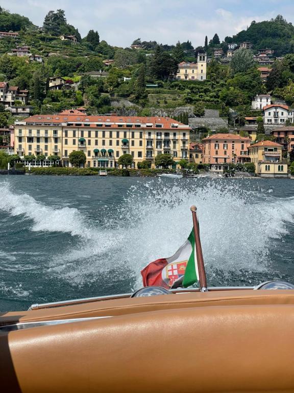 una barca con una bandiera in un corpo d'acqua di Grand Hotel Menaggio a Menaggio