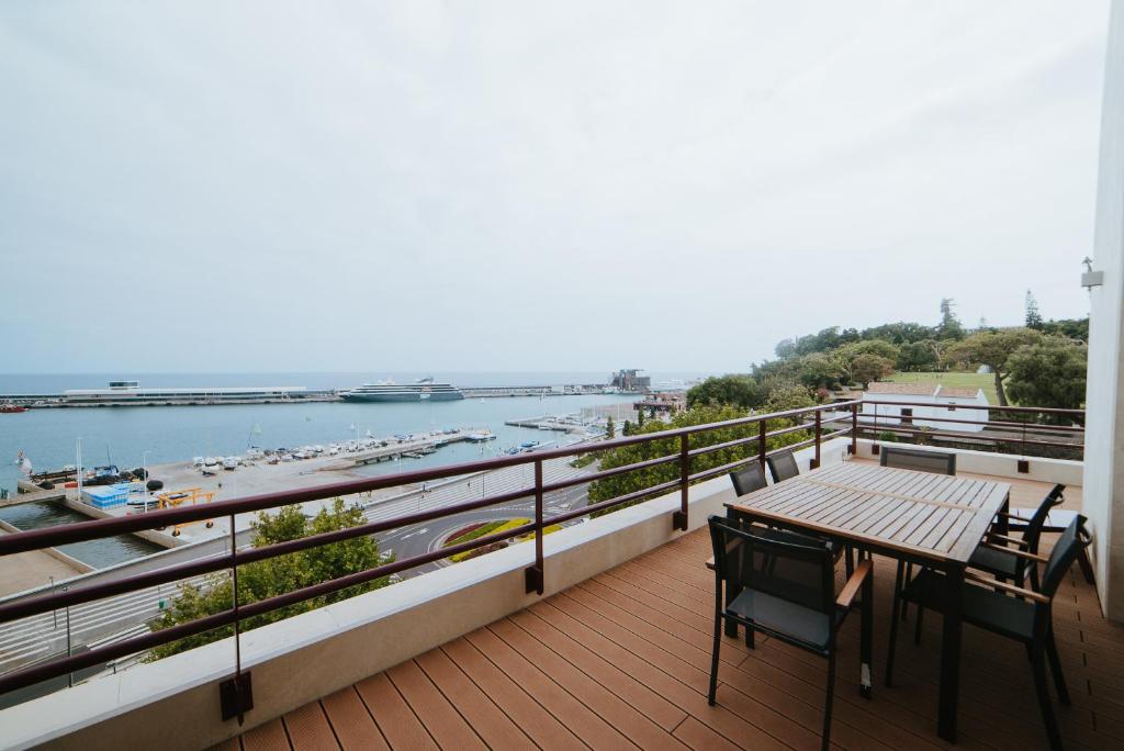 balcone con tavolo, sedie e vista sull'acqua di Rooftop Marina l by Madeira Best Apartments a Funchal