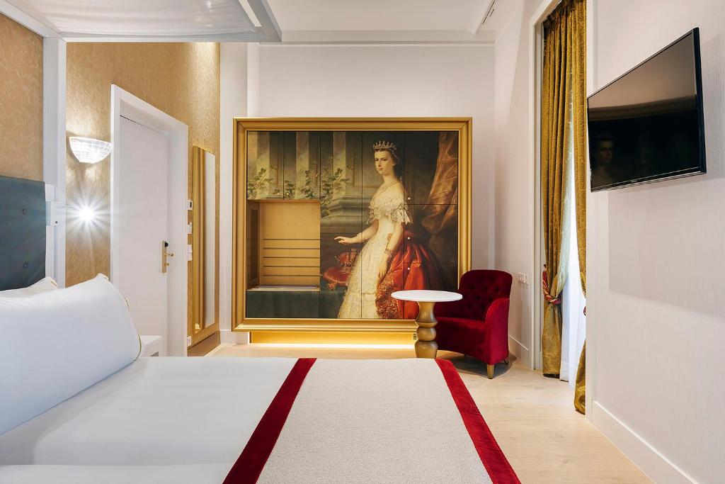 een slaapkamer met een schilderij van een vrouw aan de muur bij Áurea Ana Palace by Eurostars Hotel Company in Boedapest