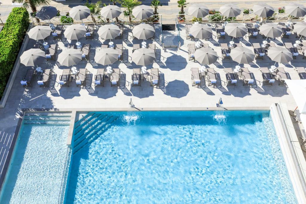 an overhead view of a pool with chairs and umbrellas at Hotel Cavalieri Palace in Lido di Jesolo