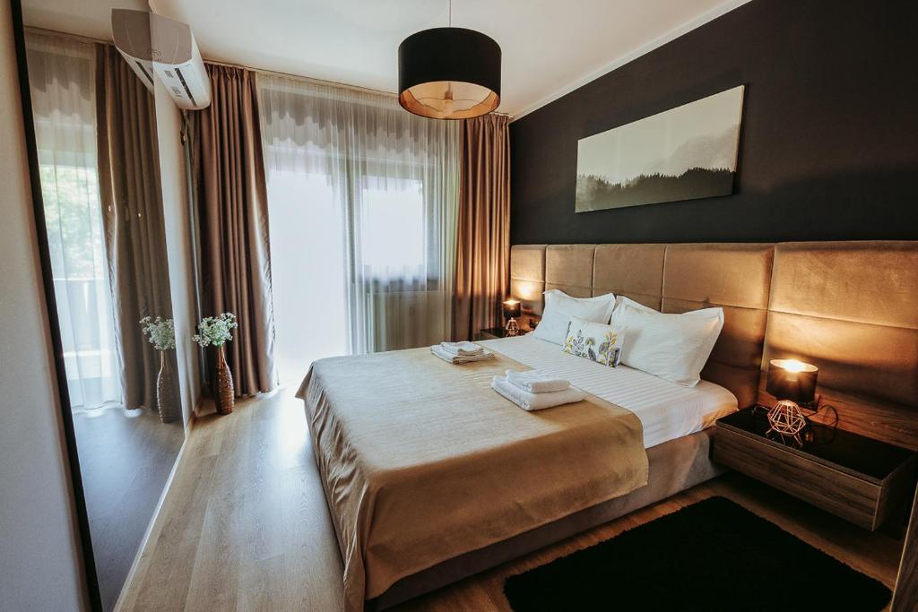 um quarto de hotel com uma cama grande e uma janela grande em Charlotte Apartment - 2Bedrooms w Parking near Nymphaea em Oradea