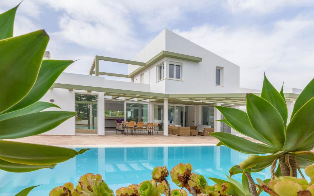 een villa met een zwembad en een huis bij Villa Santandria Grupo Seranova Luxury Hotel in Ciutadella