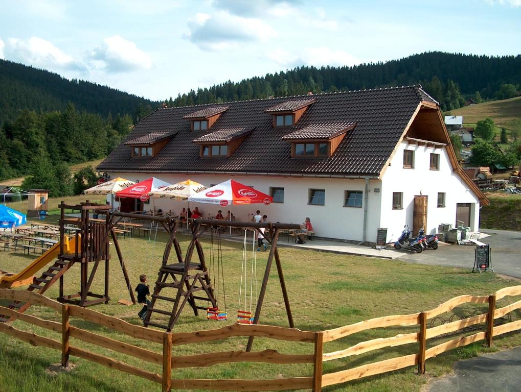 a building with a playground in front of a house at Penzion Silverado in Horní Bečva