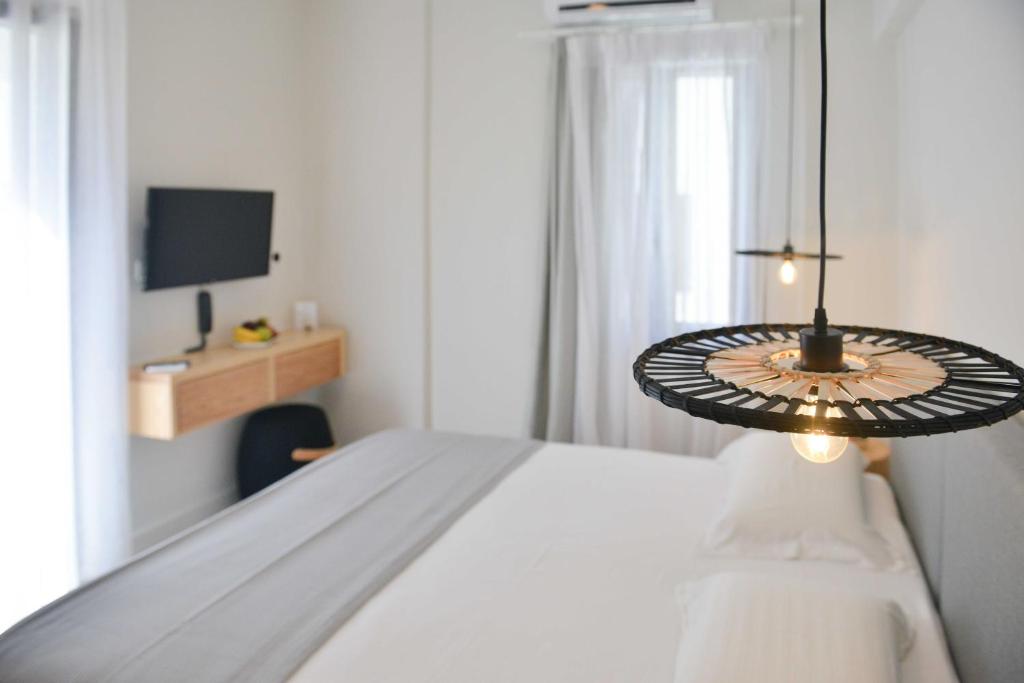 una camera bianca con letto e televisore di Princess Mare Hotel - Adults Only a Naxos Chora