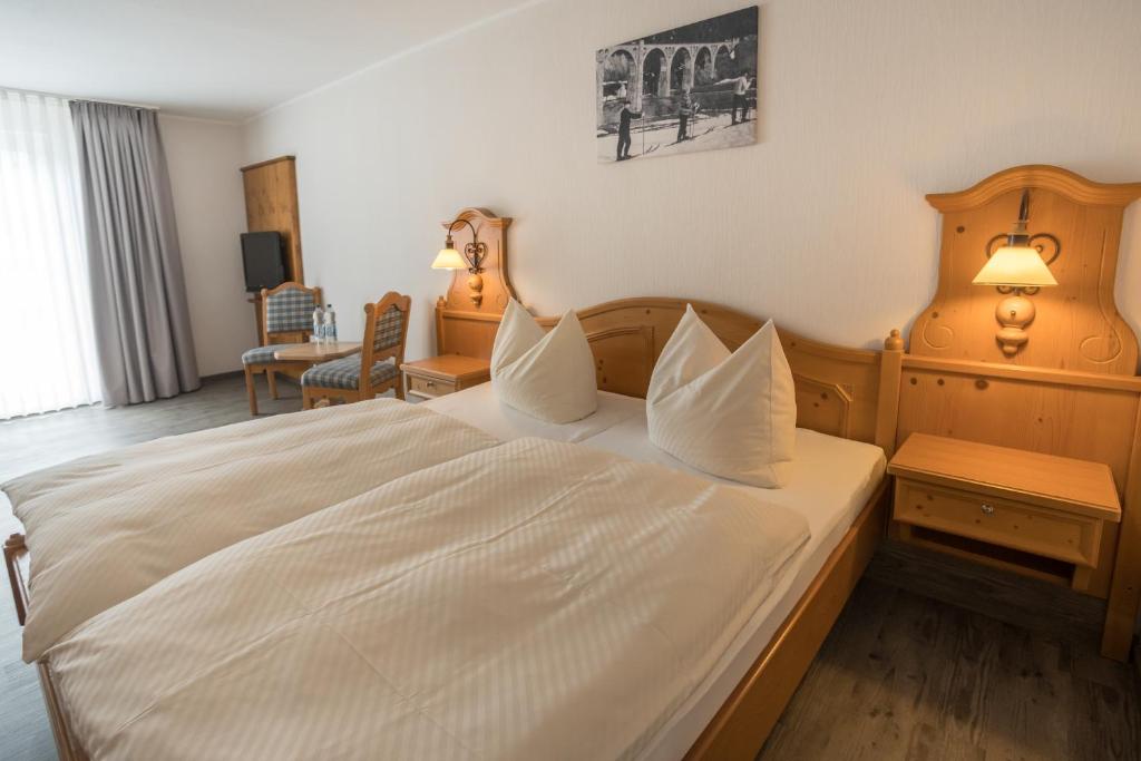 - une chambre avec un grand lit et des draps blancs dans l'établissement Hotel Willinger Mitte, à Willingen