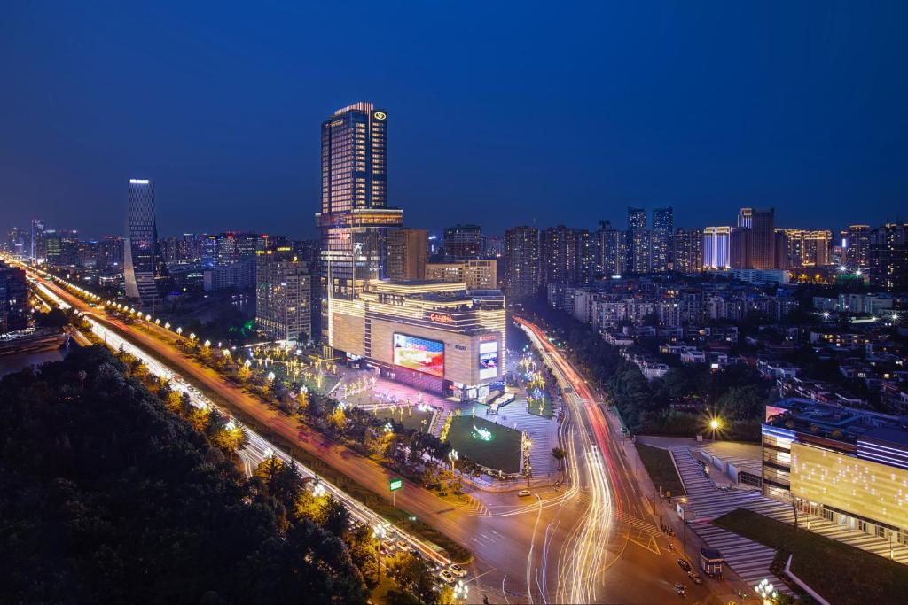 Una ciudad iluminada por la noche con tráfico en una calle en Grand Bay Hotel Chengdu, en Chengdú