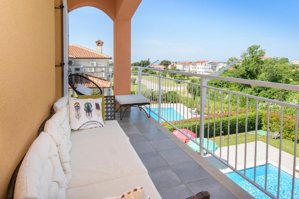 einen Balkon mit einem Sofa und Poolblick in der Unterkunft Aurea Novigrad in Novigrad Istria