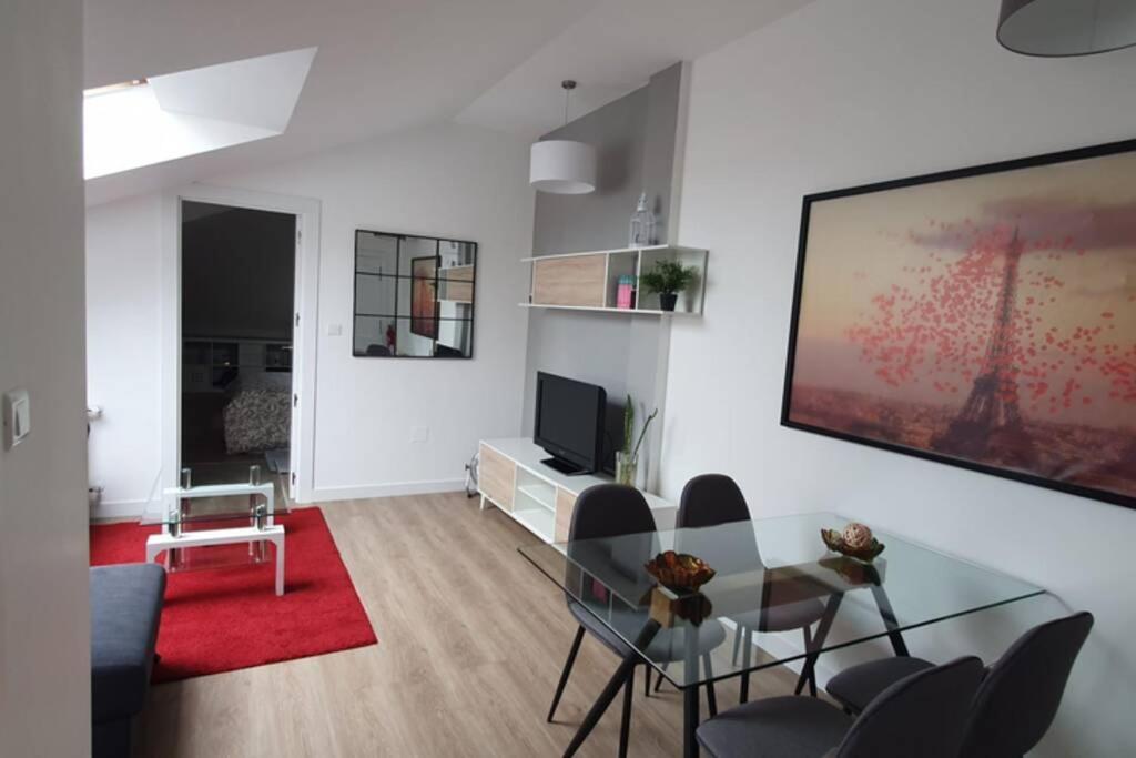 a living room with a glass table and chairs at Apartamento nuevo en El Astillero in El Astillero