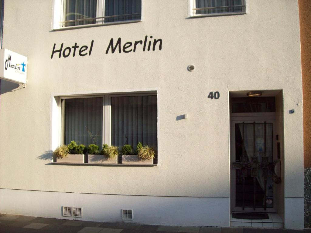 Hotel Merlin Garni في كولونيا: علامة merlin الفندق على جانب المبنى