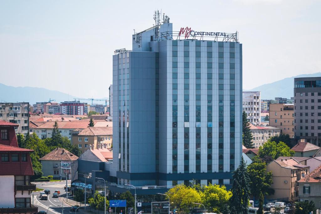 un grand bâtiment en verre au milieu d'une ville dans l'établissement MyContinental Sibiu, à Sibiu